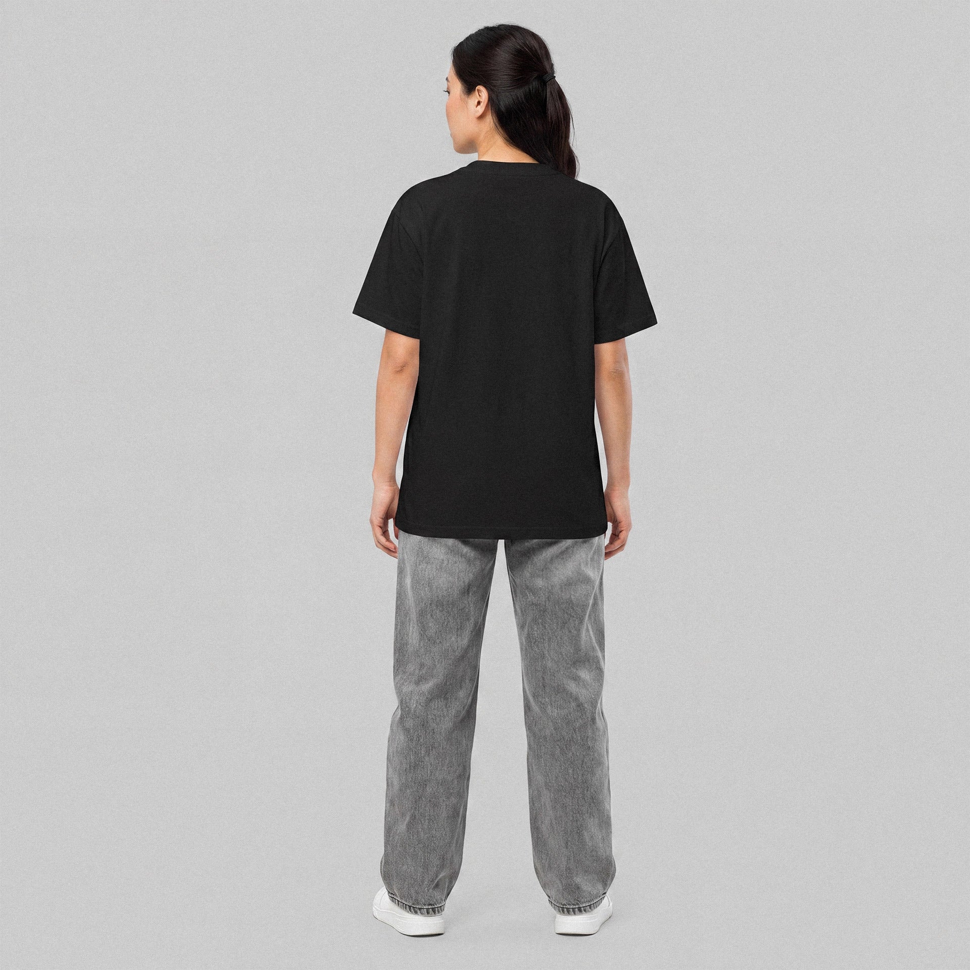 Person wearing a black t-shirt and gray pants on a gray background